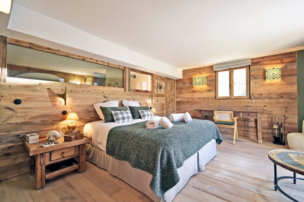 A bedroom with wooden walls and a large bed
