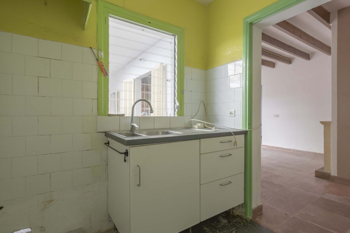 A kitchen with white cabinets and a green trim