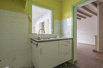 A kitchen with white cabinets and a green trim