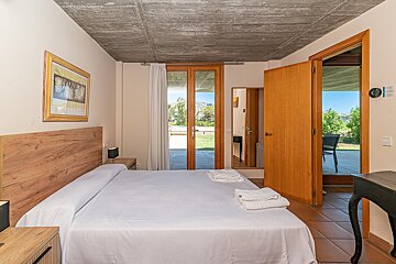 A bedroom with a large bed and a picture on the wall