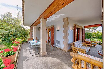 A patio with a table and chairs on it