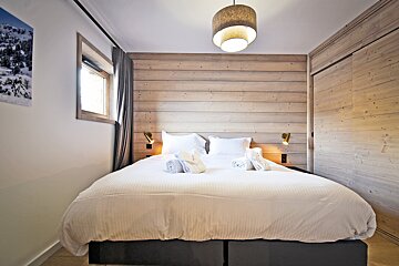A bedroom with a bed and a picture on the wall