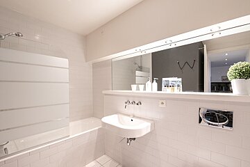 A bathroom with a sink and a large mirror
