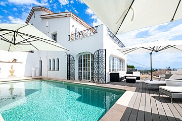A large white house with a swimming pool in front of it