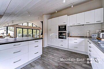 A kitchen with white cabinets and a bread box on the counter