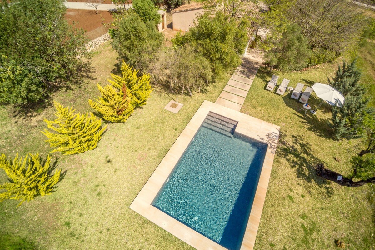 An aerial view of a large swimming pool surrounded by trees