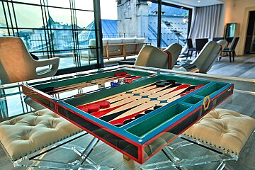 A colorful backgammon board sits on a glass table