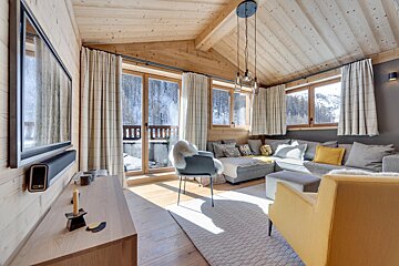 A living room with a couch and chairs and a clock that says 10:08