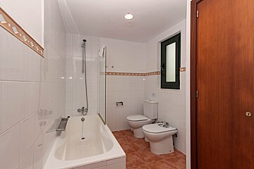 A bathroom with a bathtub toilet and bidet