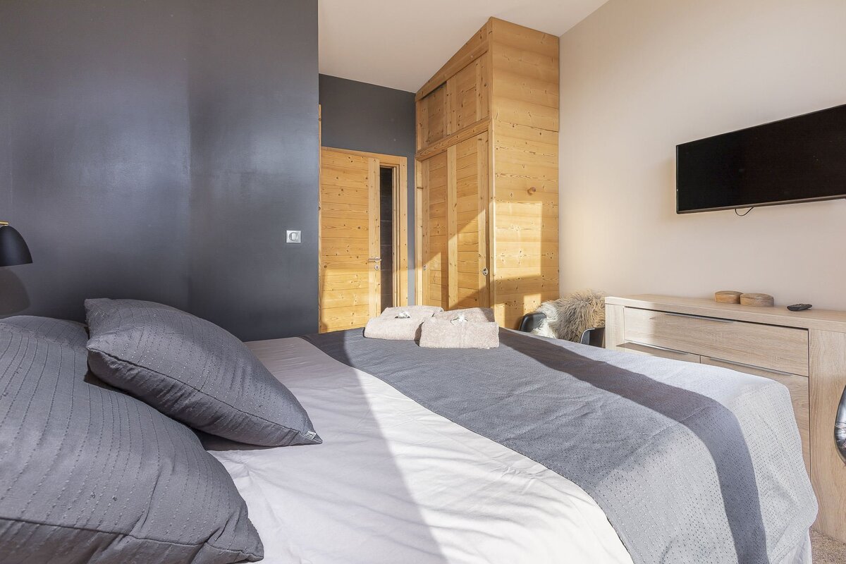 A bedroom with a large bed and a flat screen tv