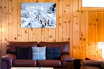 A couch in a living room with a picture on the wall above it