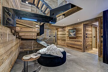 A staircase with a glass railing and wooden walls