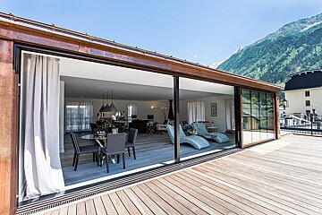 A house with a large sliding glass door leading to a deck