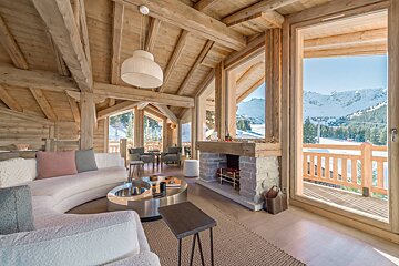 A living room with a fireplace and mountains in the background