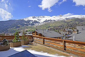 A balcony with a view of a snowy mountain range