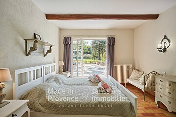A bedroom with two beds made in provence by janssens immobilier