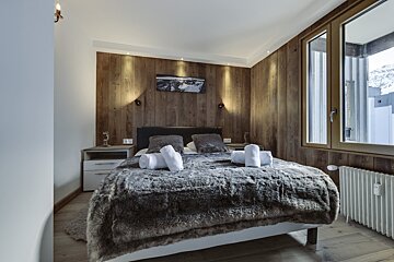A bedroom with a bed and a picture on the wall