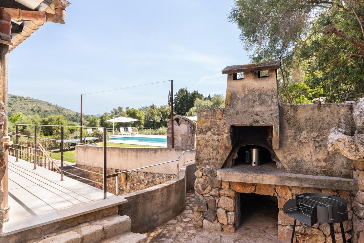 A stone oven sits next to a swimming pool