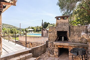 A stone oven sits next to a swimming pool