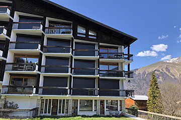 A large building with balconies and mountains in the background