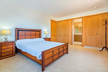 A bedroom with a large bed and lots of closets