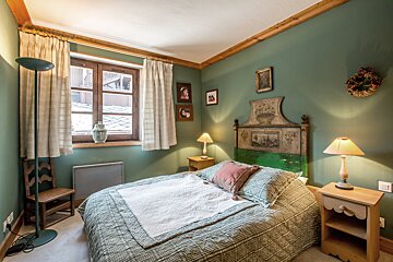 A bedroom with green walls and a bed