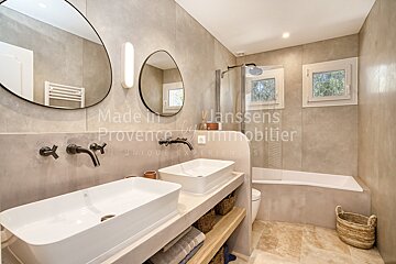 A bathroom with two sinks and two mirrors made by janssens provence immobilier