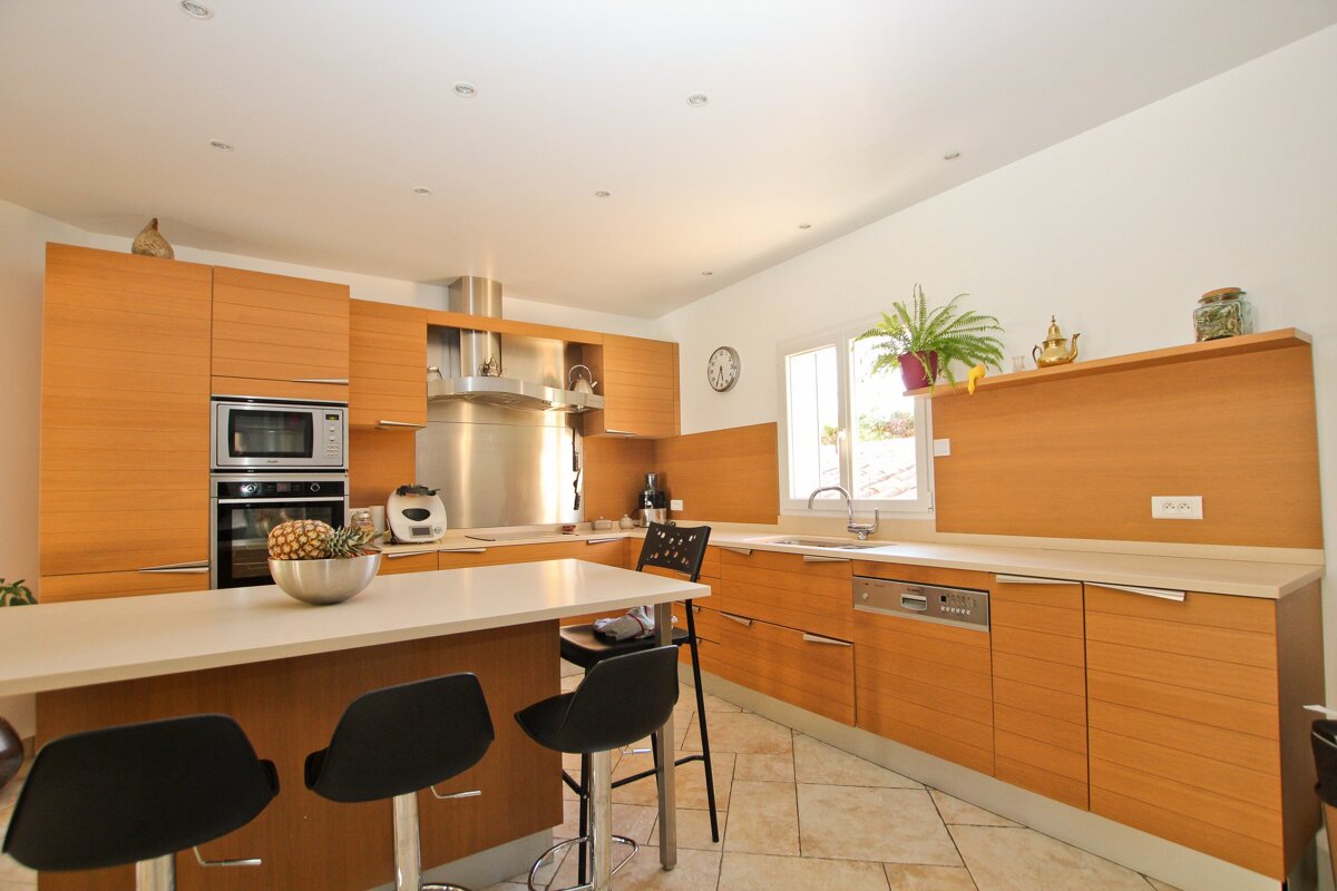 A kitchen with wooden cabinets and a clock on the wall