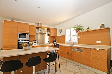 A kitchen with wooden cabinets and a clock on the wall