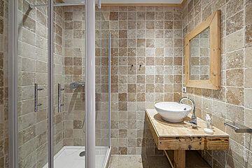 A bathroom with a walk in shower and a sink