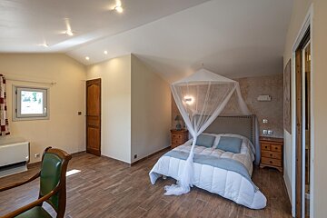 A bedroom with a canopy bed and two nightstands