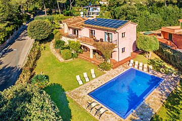 An aerial view of a house with a pool and solar panels on the roof