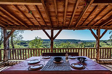 A table with a checkered table cloth and a bottle of wine on it