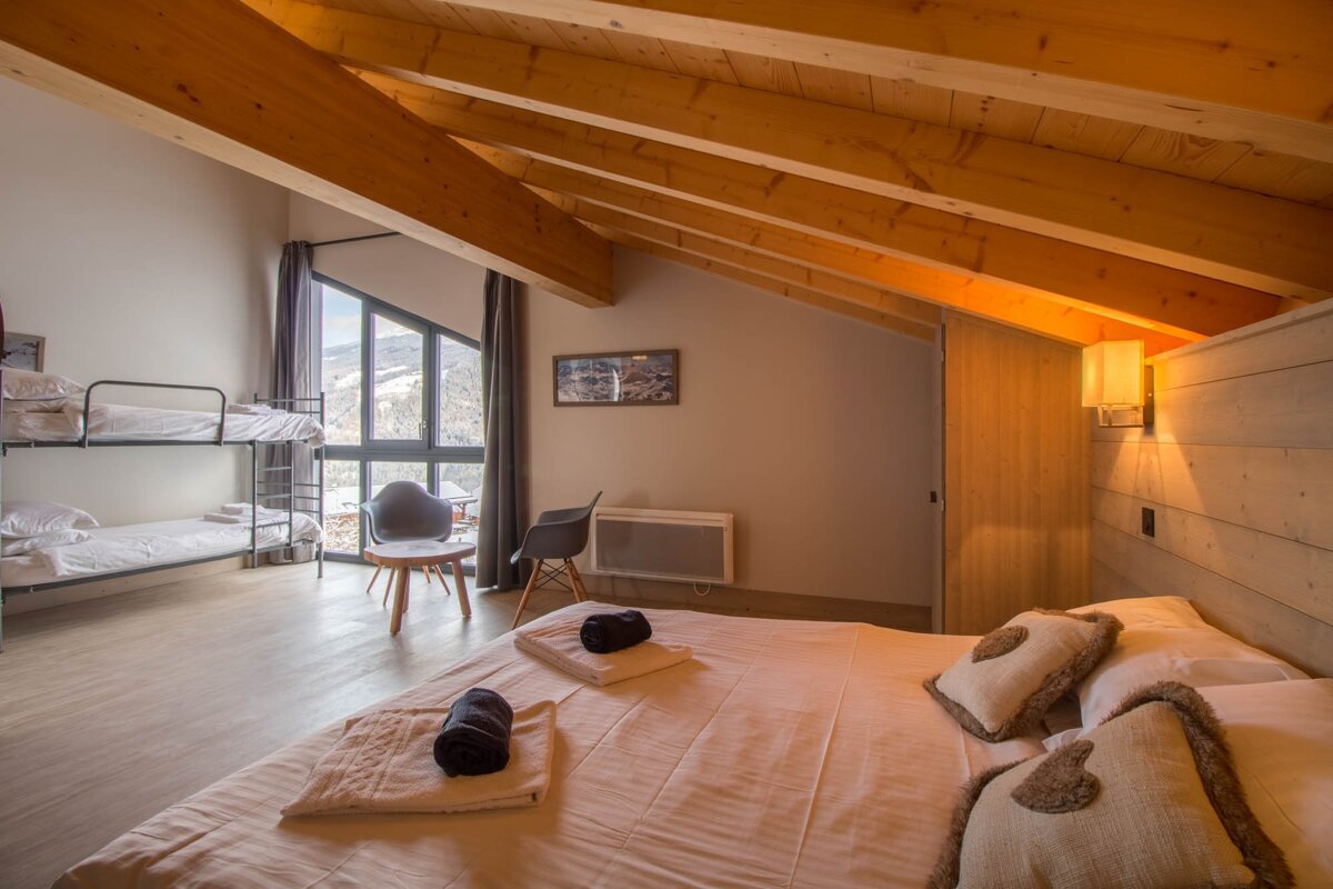 A bedroom with a bunk bed and a large bed