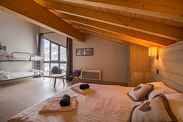A bedroom with a bunk bed and a large bed