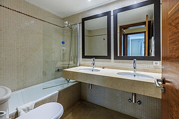 A bathroom with two sinks and a bathtub