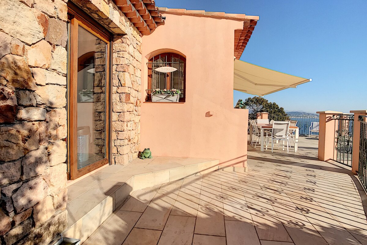 A balcony with a table and chairs and an awning over it
