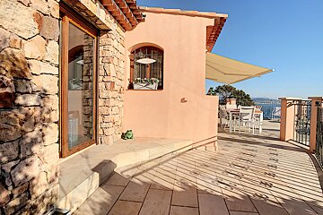 A balcony with a table and chairs and an awning over it