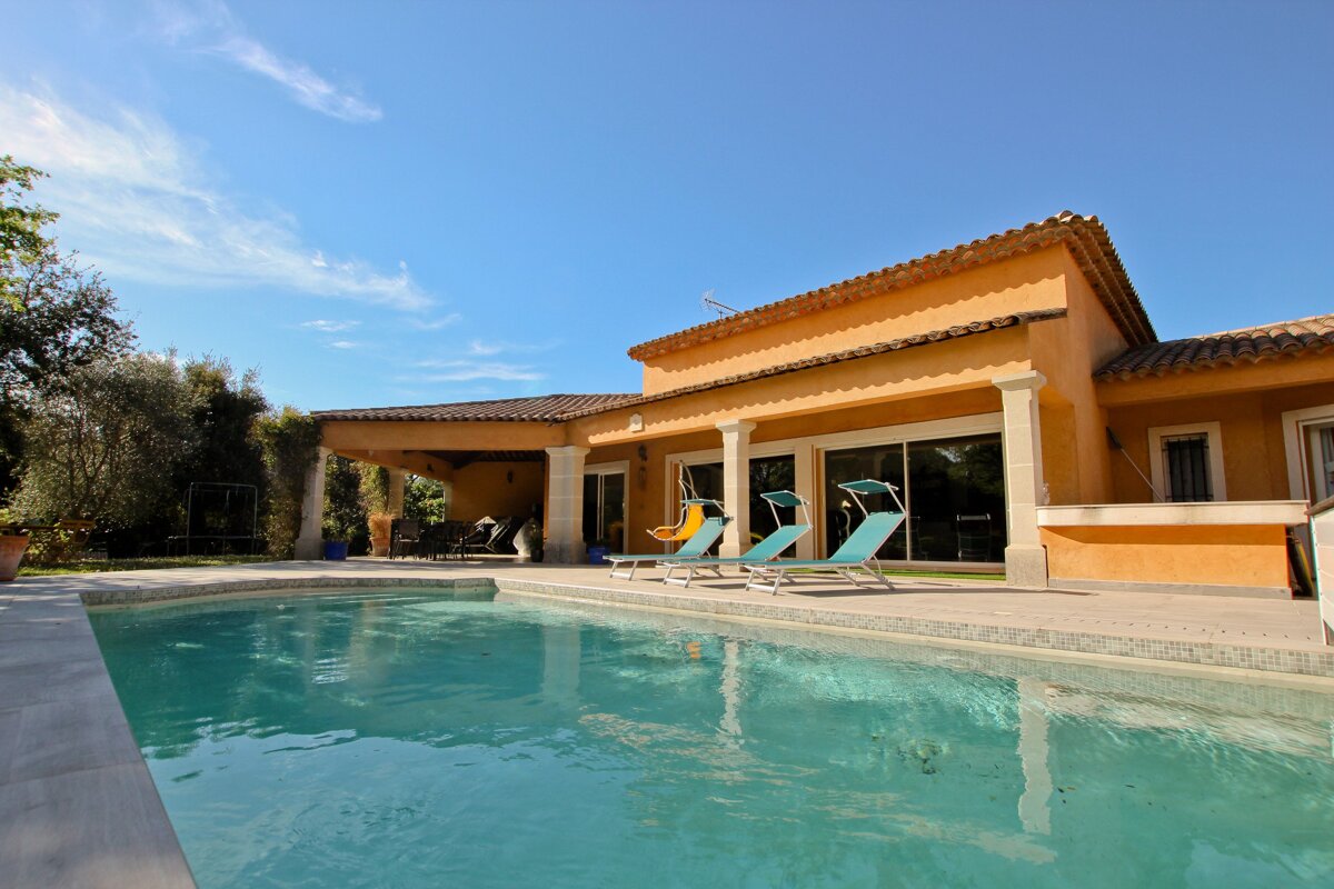 A large house with a swimming pool in front of it