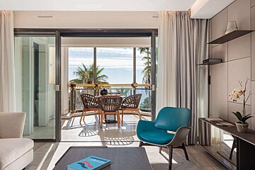 A living room with a table and chairs and a book on the table that says turquoise color