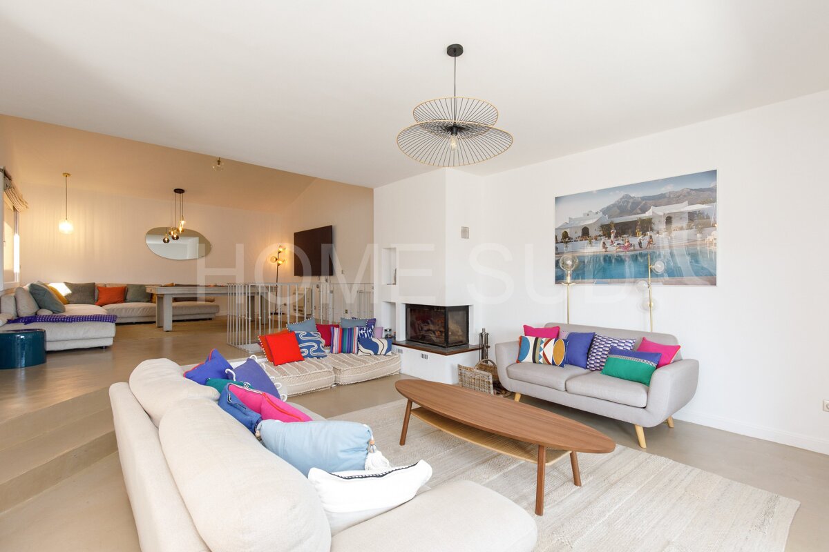 A living room with a painting of a pool on the wall