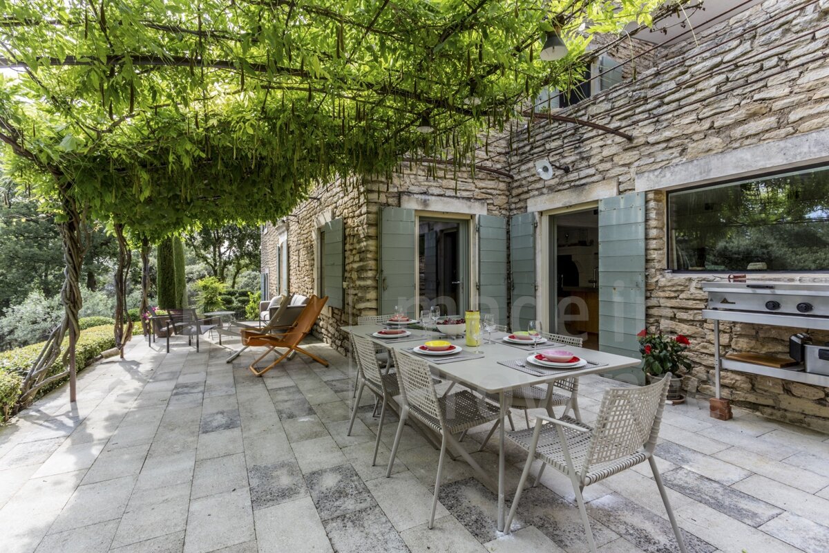 A patio with a table and chairs under a tree