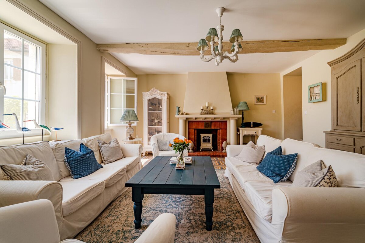 A living room with white furniture and a fireplace