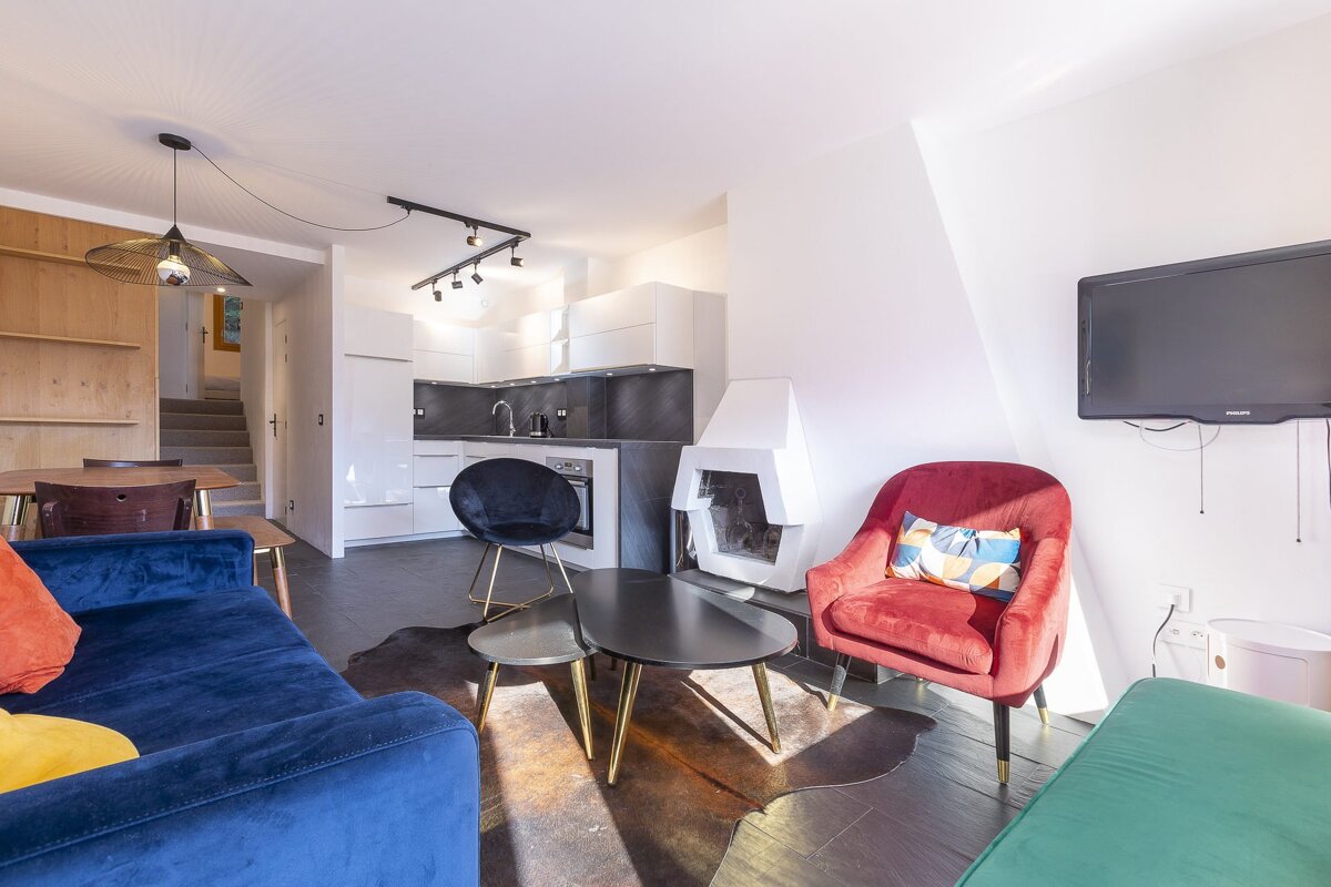 A living room with a blue couch and two red chairs