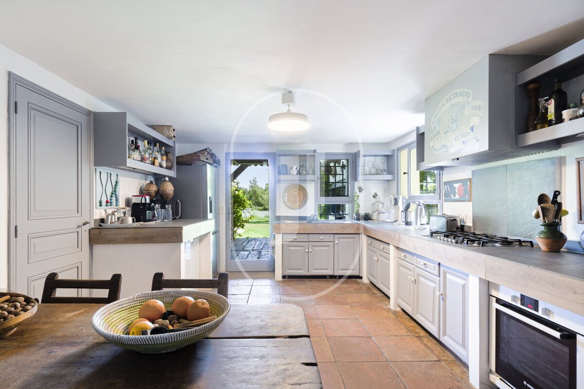A kitchen with a bowl of fruit on the table