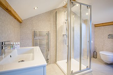 A bathroom with a walk in shower and a sink