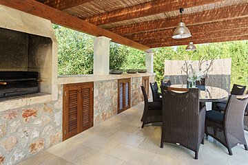 A patio with a table and chairs and a grill