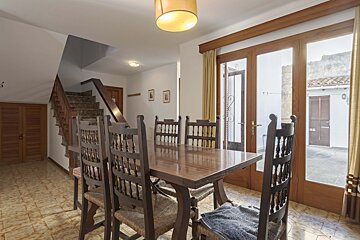 A dining room with a table and chairs and stairs