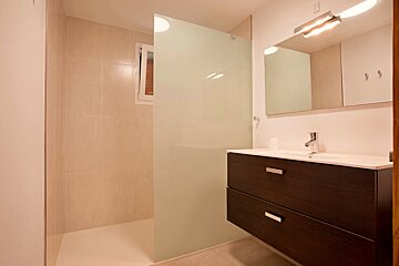 A bathroom with a sink and a walk in shower