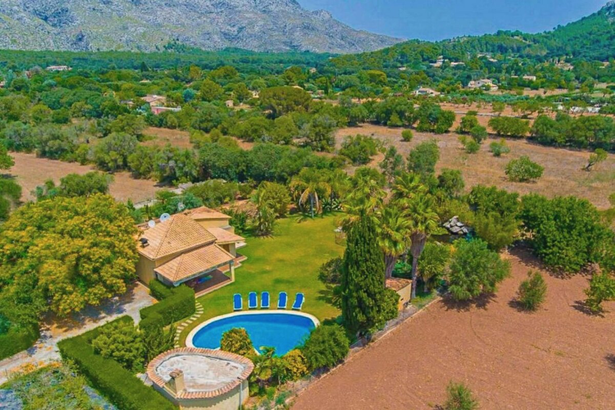 An aerial view of a house with a large pool